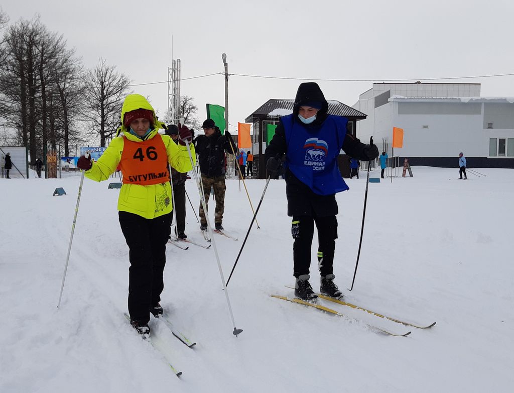 Волонтёр выступает в качестве лидера на дистанции для незрячей лыжницы