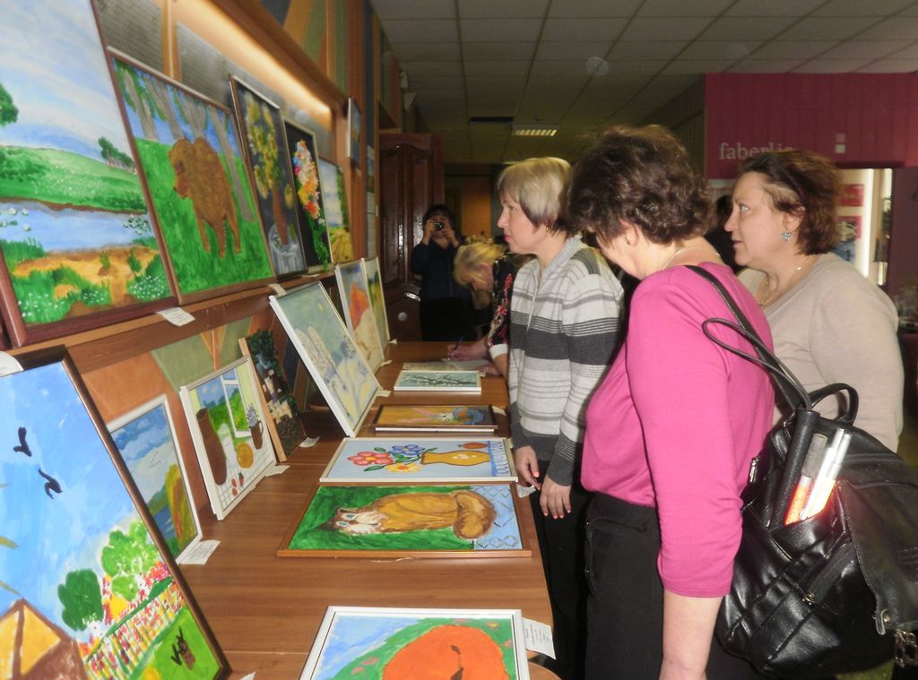 Посетители выставки с интересом осматривают картины