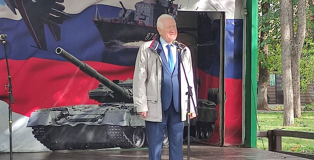 Ю. С. Третьяк на сцене на фоне флага России