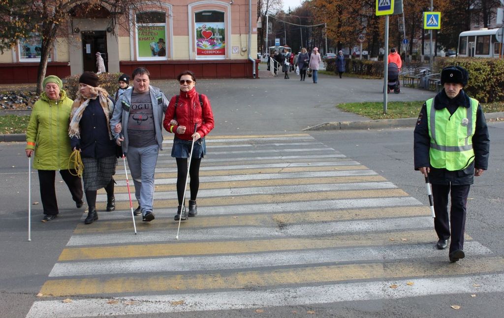 Незрячие пешеходы переходят дорогу на зебре