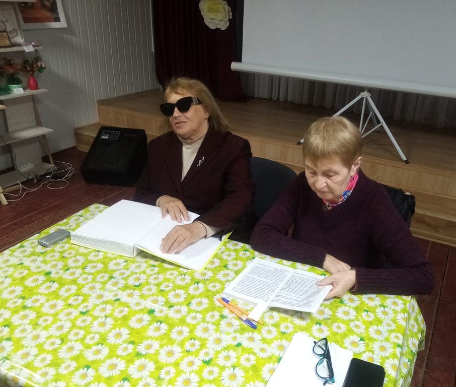 Две женщины читают текст по Брайлю