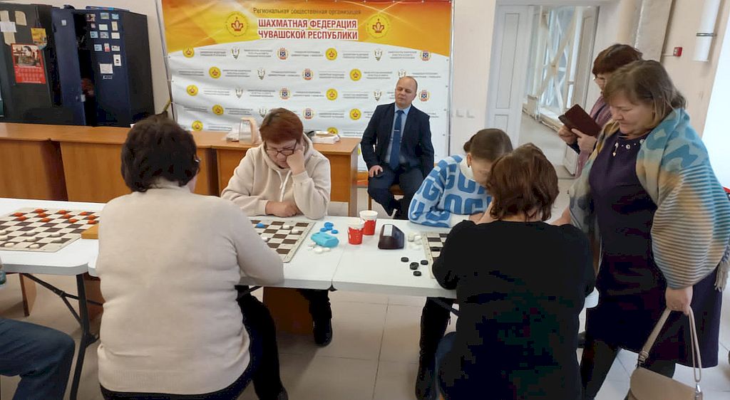 Участники состязаний играют в шашки