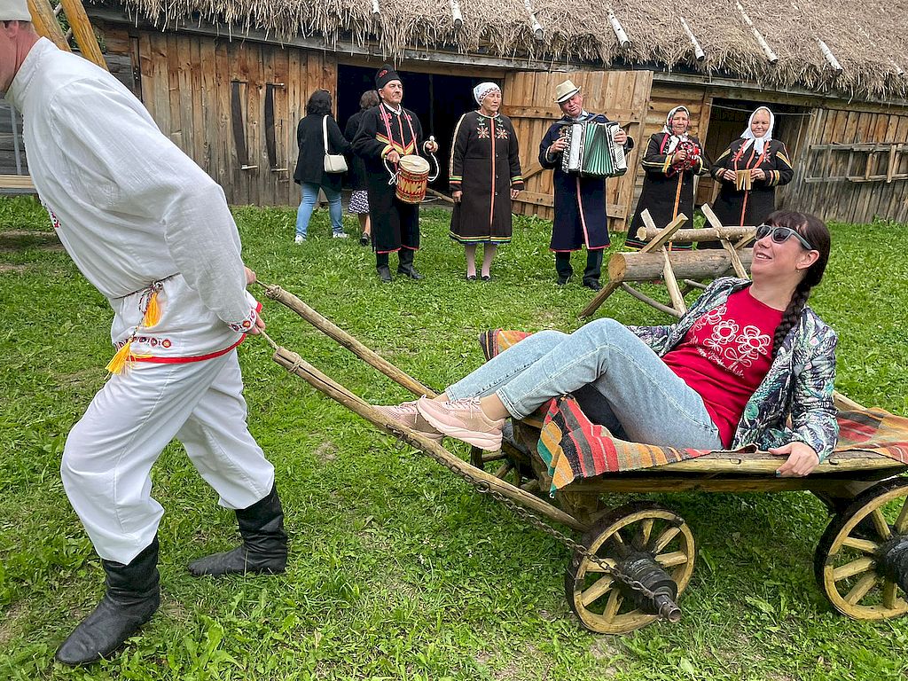 Участница форума катается по двору на старинной повозке