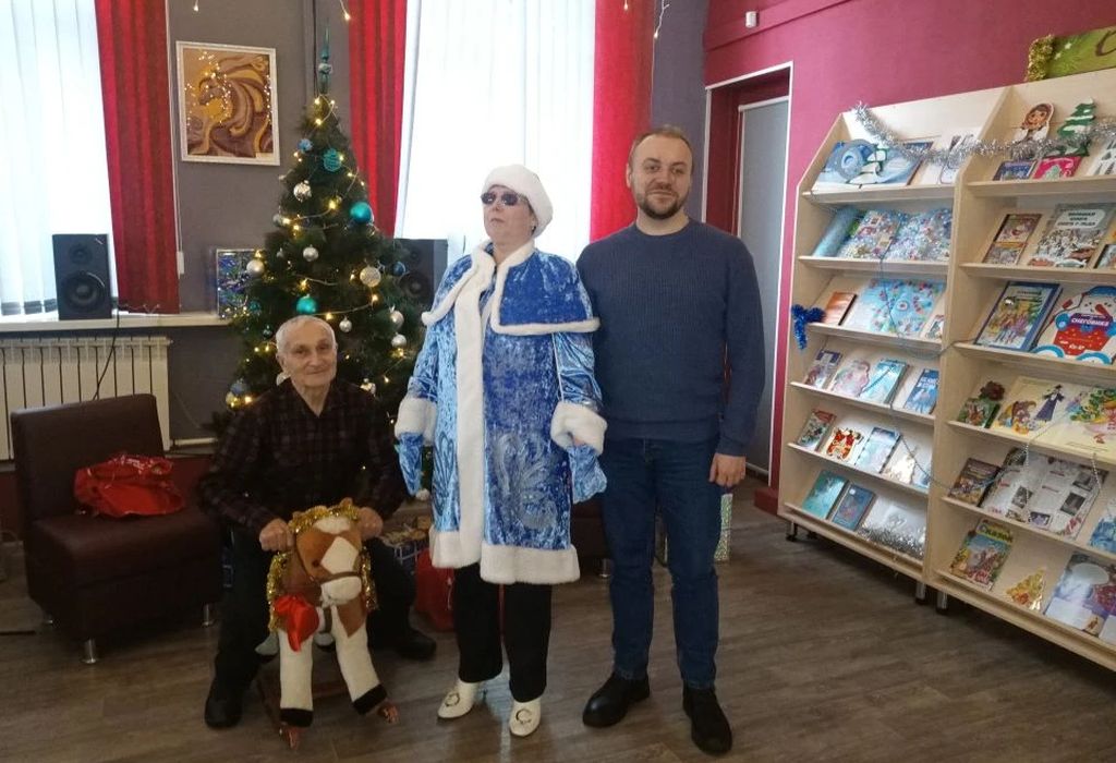 участники мероприятия в библиотеке у наряженной ёлки