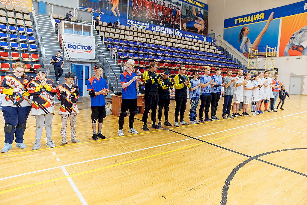 Спортсмены в спортивной форме стоят в шеренгу