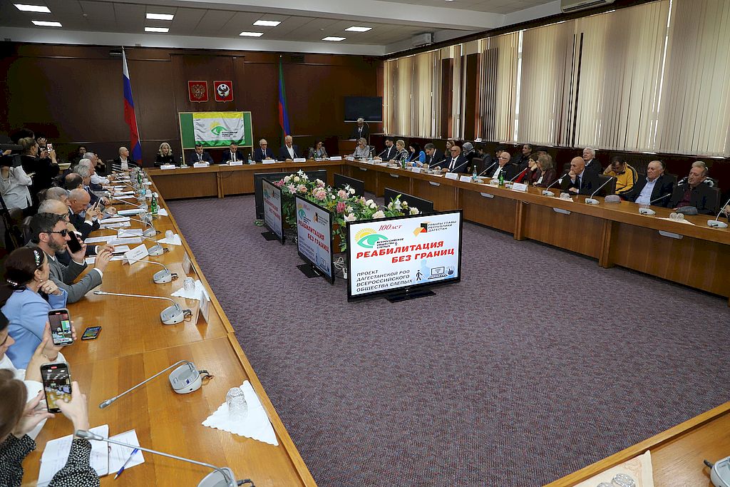 участники форума сидят за столами. перед ними стоят микрофоны