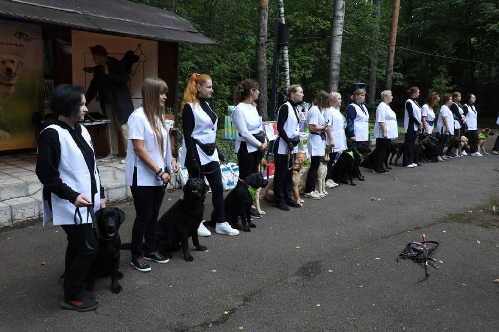 инструкторы школы собак-проводников со своими собаками