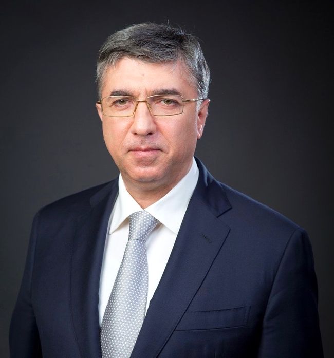 Портретное фото Д. М. Магомедова. Взрослый седой мужчина в очках, в костюме и галстуке