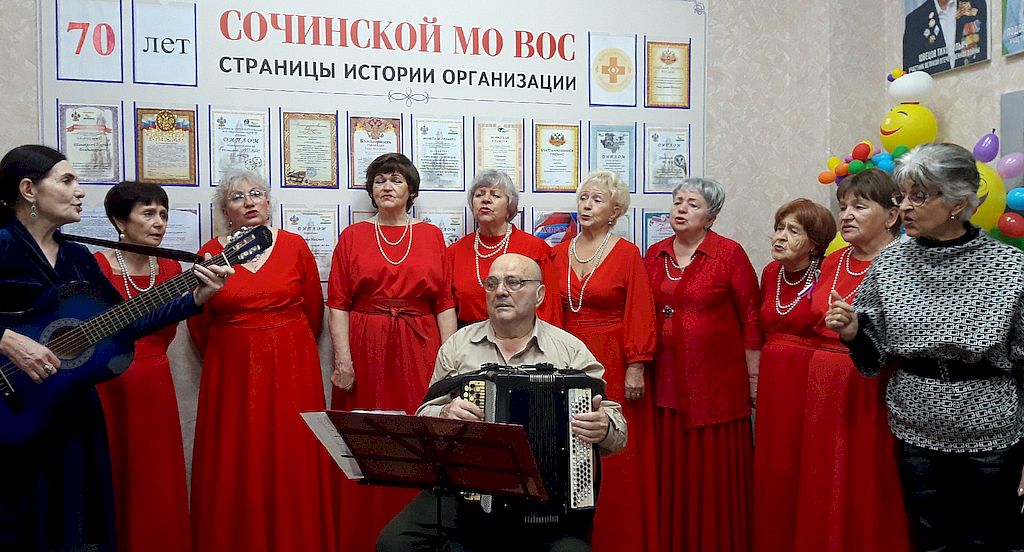 На фотографии 10 женщин и мужчина с баяном.