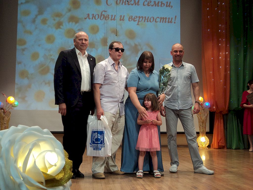 На сцене участники мероприятия с цветами и подарками