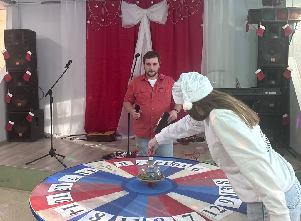 участница квиза вращает рулетку с номерами вопросов