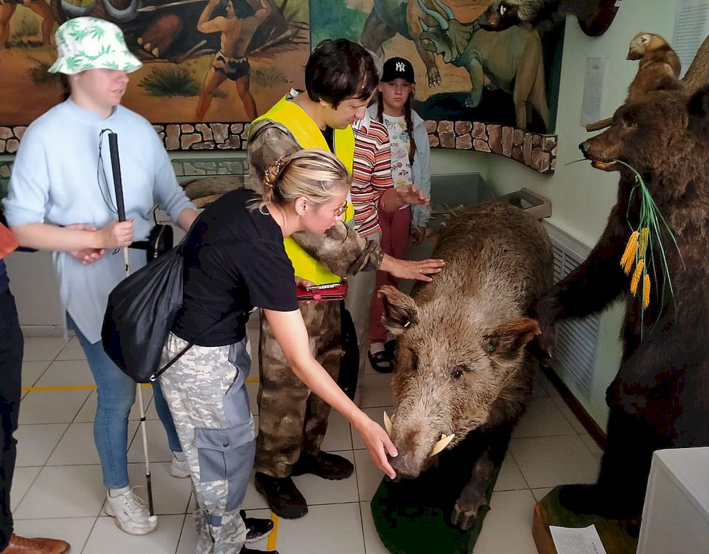 Участники мероприятия в музее осматривают чучело медведя