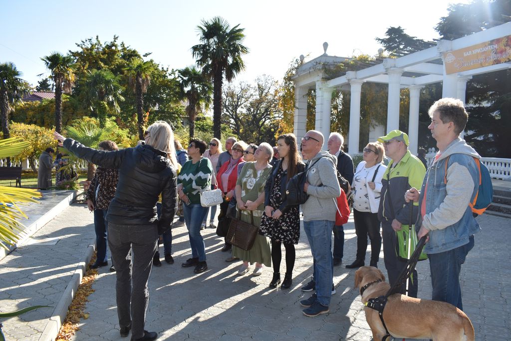 Экскурсовод рассказывает группе незрячих туристов о главных достопримечательностях Никитского ботанического сада