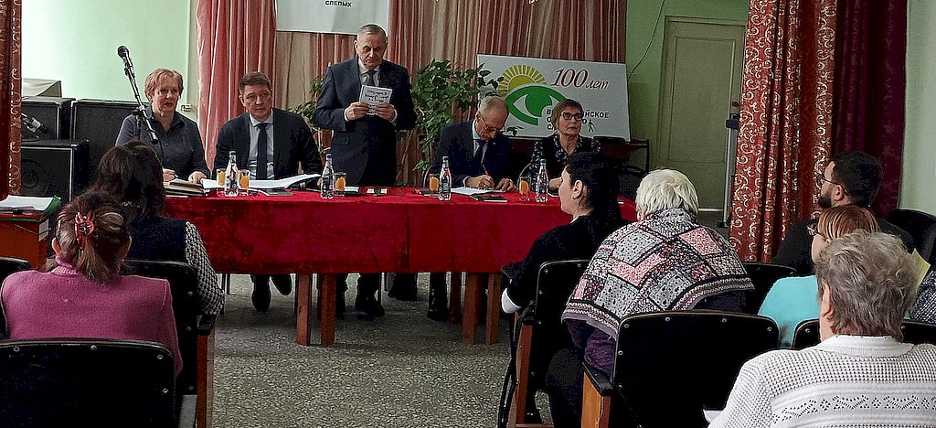 В центре зала - стол, за которым сидит президиум конференции