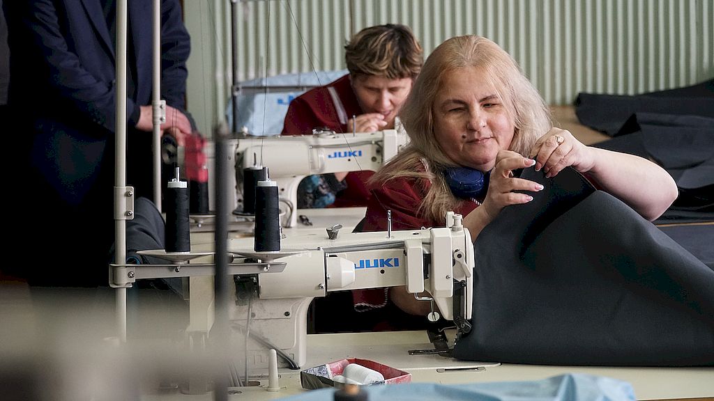 Работницы предприятия шьют на швейных машинках.