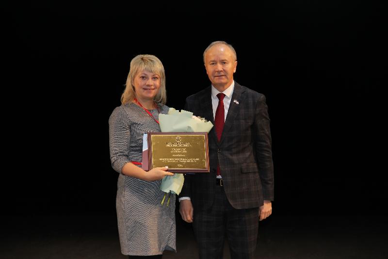 Главный бухгалтер предприятия ВОС ООО "МП "Искра" Е. Е. Гундырева принимает памятную плакетку из рук ведущего церемонии награждения