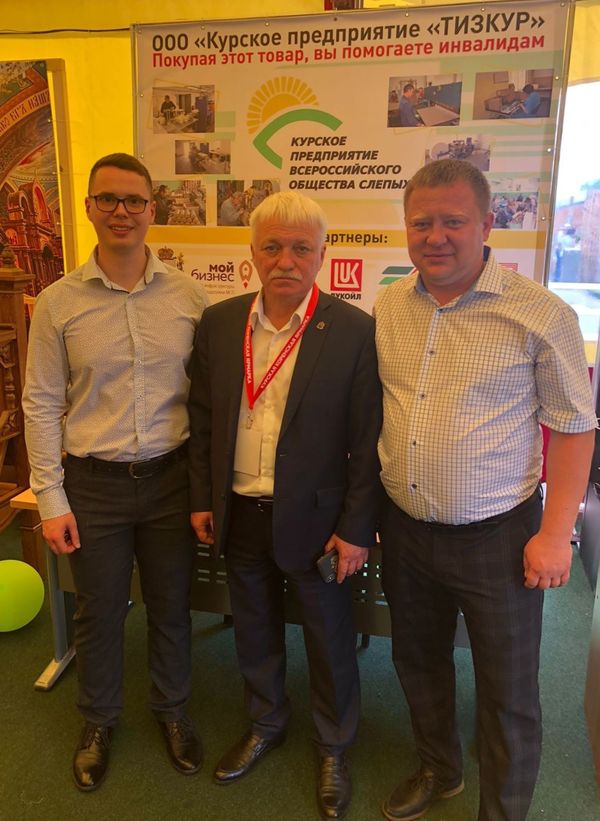 Представители предприятия ВОС на фоне стенда ООО "КП "Тизкур"